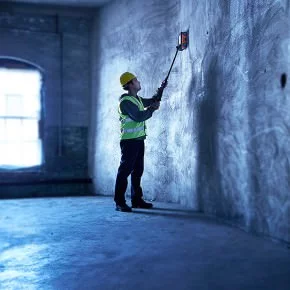 A worker scanning the wall with a device.