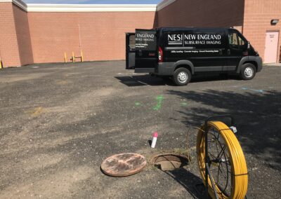 A parked black NESI van in an empty lot.