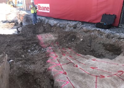 An excavated ground shows a large underground tank with arrow markings.