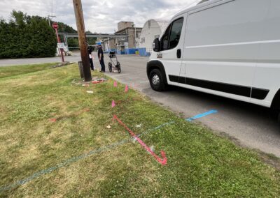 Orange and blue line markings on the ground beside a parked white van