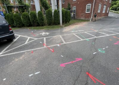 A driveway with blue and orange markings on the ground with a parked black van in the corner.